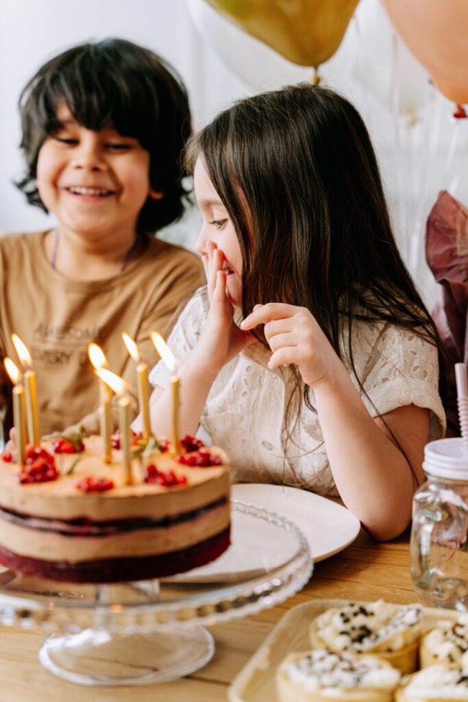 Niños celebrando un cumpleaños con pastel y velas